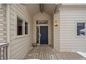 Front entrance with a dark blue door and wood deck at 7329 Windsor Dr, Boulder, CO 80301