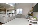 Bright living room with a high ceiling, a large sectional sofa, and natural light at 802 Gamble Oak St, Brighton, CO 80601