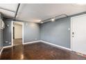 A modern living room with industrial accents, neutral paint, and a glimpse of a carpeted bedroom at 500 E 11Th Ave # 102, Denver, CO 80203