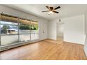 Bright living room featuring hardwood floors, large window and a ceiling fan at 9095 Beechwood Dr, Thornton, CO 80229