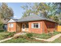 Brick home with lush landscaping and a welcoming walkway, showcasing a blend of charm and curb appeal at 1610 Xanthia St, Denver, CO 80220