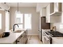 Bright kitchen features white cabinets, modern appliances, and a large center island with quartz countertops at 8260 E 36Th Ave # 30, Denver, CO 80238