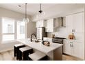 Stylish kitchen featuring stainless appliances, quartz countertops, a center island, and globe pendant lighting at 8260 E 36Th Ave # 30, Denver, CO 80238