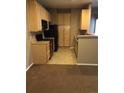 Bright kitchen featuring wood cabinets, black appliances, and tile flooring with plenty of storage at 1575 Olympia Cir # 208, Castle Rock, CO 80104