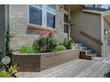 Inviting porch with a garden bed featuring vibrant flowers and a wooden deck at 8258 S Reed Way, Littleton, CO 80128