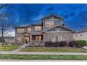 Inviting two-story home boasts stone facade, covered porch, manicured lawn, and desirable neighborhood charm at 10459 Rivington Ct, Lone Tree, CO 80124