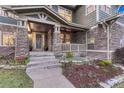 Inviting front porch with stone accents, manicured landscaping, and a welcoming entrance at 10459 Rivington Ct, Lone Tree, CO 80124