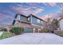 Spacious three-car garage with an extended driveway and lush landscaping at 10459 Rivington Ct, Lone Tree, CO 80124