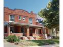 Charming brick duplex with covered front porch and lush landscaping at 126 S Clarkson St, Denver, CO 80209