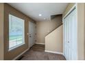Inviting entryway features a window, coat closet, neutral walls, and view of the staircase at 1419 Red Mountain Dr # 126, Longmont, CO 80504