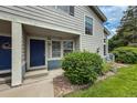 Close-up of unit exterior with blue door and well-manicured landscaping and stone ground cover at 1419 Red Mountain Dr # 126, Longmont, CO 80504