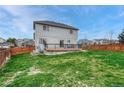 A large backyard with green grass and a wooden fence surrounds the property and a deck at 600 Balsa Dr, Castle Rock, CO 80104
