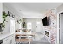 Bright living room with a leather couch, brick fireplace, and an open floor plan at 1531 W Dakota Ave, Denver, CO 80223