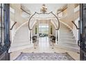 Grand foyer showcasing a dual staircase, chandelier, and elegant tile flooring at 5672 S Nome St, Englewood, CO 80111
