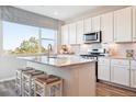 Bright, spacious kitchen with white cabinets, granite countertops, an island, and stainless steel appliances at 451 Interlocken Blvd # 101, Broomfield, CO 80021