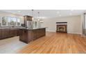 Open kitchen featuring a spacious island, hardwood floors, stainless steel appliances, and brick fireplace at 80 S 38Th St, Boulder, CO 80305