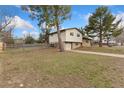 Spacious yard featuring a split-level home with an attached garage and partial fence at 80 S 38Th St, Boulder, CO 80305
