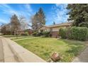 Well-maintained lawn and landscaping with mature trees complement this charming ranch-style home at 6832 S Birch Way, Centennial, CO 80122