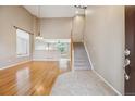 Bright foyer with hardwood floors, stairs to upper level, and views of the living spaces at 4016 S Rome St, Aurora, CO 80018