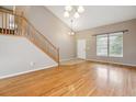 Light-filled living room features hardwood floors, staircase, and vaulted ceiling at 4016 S Rome St, Aurora, CO 80018