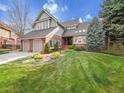 Charming front exterior featuring a brick facade, lush green lawn and mature landscaping at 6505 S Garfield Ct, Centennial, CO 80121