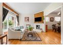 Bright living room with a brick fireplace, hardwood floors, and large windows at 2944 Hooker St, Denver, CO 80211