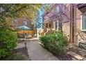 Beautiful patio area with lush landscaping, dining set, and shade for relaxing outdoors at 999 N Emerson St # 10, Denver, CO 80218