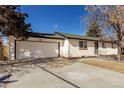 This single-story home features a white brick exterior, a front-facing garage, and a well-kept lawn at 6699 S Pennsylvania St, Centennial, CO 80121