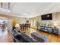 Bright living room with hardwood floors, large windows, comfortable seating, and adjacent dining area at 4901 Ashbrook Cir, Highlands Ranch, CO 80130