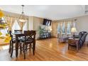 Open-concept living area with hardwood floors, dining table, media center, and plenty of natural light at 4901 Ashbrook Cir, Highlands Ranch, CO 80130