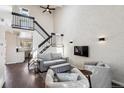 Bright living room boasts high ceilings, modern furnishings, and a staircase leading to the upper level at 10309 W Fair Ave # E, Littleton, CO 80127