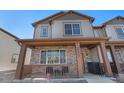 Charming two-story home featuring a covered front porch with stone accents and stylish gray siding at 20932 E 60Th Ave, Aurora, CO 80019
