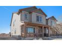 Charming two-story home featuring a covered front porch with stone accents and stylish gray siding at 20932 E 60Th Ave, Aurora, CO 80019