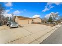 Spacious two-car garage and long driveway offer ample parking, complemented by the home's charming curb appeal at 6545 Union St, Arvada, CO 80004