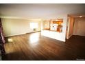 Bright, open-concept living space with wood flooring and neutral walls, adjacent to the kitchen area with updated appliances at 13890 E Marina Dr # 602, Aurora, CO 80014