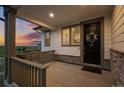 Charming front porch with a decorative wreath, a door mat, and natural stone accents at 6696 Kenzie Cir, Castle Pines, CO 80108
