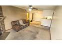 Open living area featuring neutral carpet, fireplace, and easy access to kitchen and dining at 14102 E Colorado Dr # 102, Aurora, CO 80012