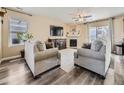 Bright living room with a fireplace, ceiling fan, wood-look floors, and neutral decor at 2508 Coach House Loop, Castle Rock, CO 80109