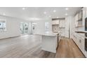 Bright, open-concept kitchen with large island, modern appliances, and hardwood flooring at 9277 Truckee Ct, Commerce City, CO 80022
