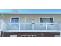 Front view of a light gray building with a balcony and brick base at 3705 Quail St # 4, Wheat Ridge, CO 80033