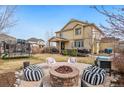 Relaxing backyard featuring a stone fire pit, stylish seating, a patio, and a trampoline at 10995 Quintero St, Commerce City, CO 80022