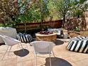 Outdoor patio with cozy seating around a stone fire pit, perfect for relaxing and entertaining in a private backyard at 10995 Quintero St, Commerce City, CO 80022