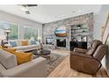 Comfortable living room with a stone accent wall, built-in shelves, and lots of natural light at 6553 S Sedalia St, Aurora, CO 80016