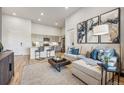 Comfortable living room featuring modern decor, a plush sofa, and an open layout to the kitchen at 487 Interlocken Blvd # 104, Broomfield, CO 80021