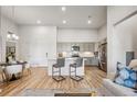 Bright living space with stainless steel appliances, gray cabinets, and a kitchen island with barstool seating at 487 Interlocken Blvd # 104, Broomfield, CO 80021