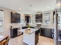 Stylish kitchen featuring dark cabinets, granite countertops, stainless steel appliances, and a functional island at 10071 Belvedere Cir, Lone Tree, CO 80124
