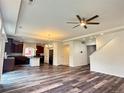 Bright open-concept living room and kitchen with hardwood floors and modern ceiling fan at 133 Poppy View Ln, Erie, CO 80516