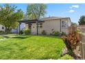 A beautiful home featuring a lovely green lawn, mature trees, and an inviting pergola at 785 Dexter St, Denver, CO 80220