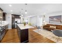 Open concept living space with hardwood floors, a modern kitchen, and stylish decor at 785 Dexter St, Denver, CO 80220