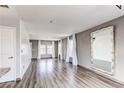 Spacious living room with wood floors, gray walls, and ample natural light from the three windows at 3607 Dinosaur St, Castle Rock, CO 80109